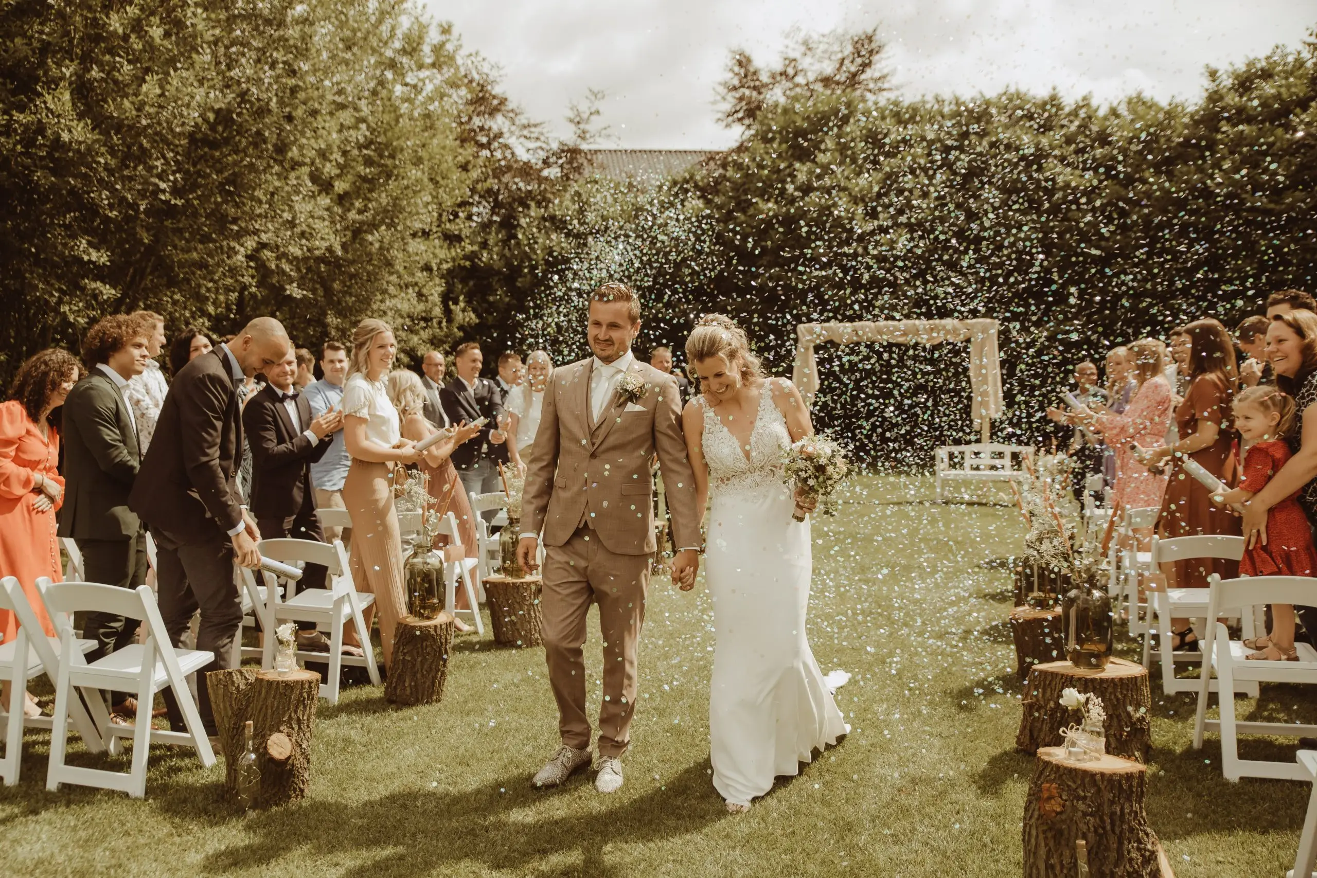Pasgetrouwd stel verlaat de ceremonie door een regen van confetti