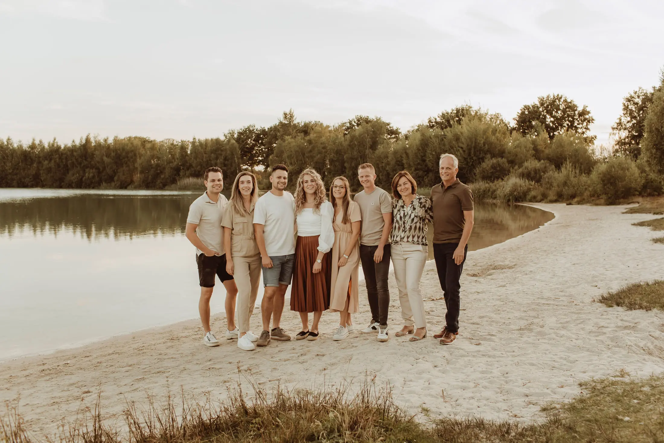 Grote familie staat samen aan het water