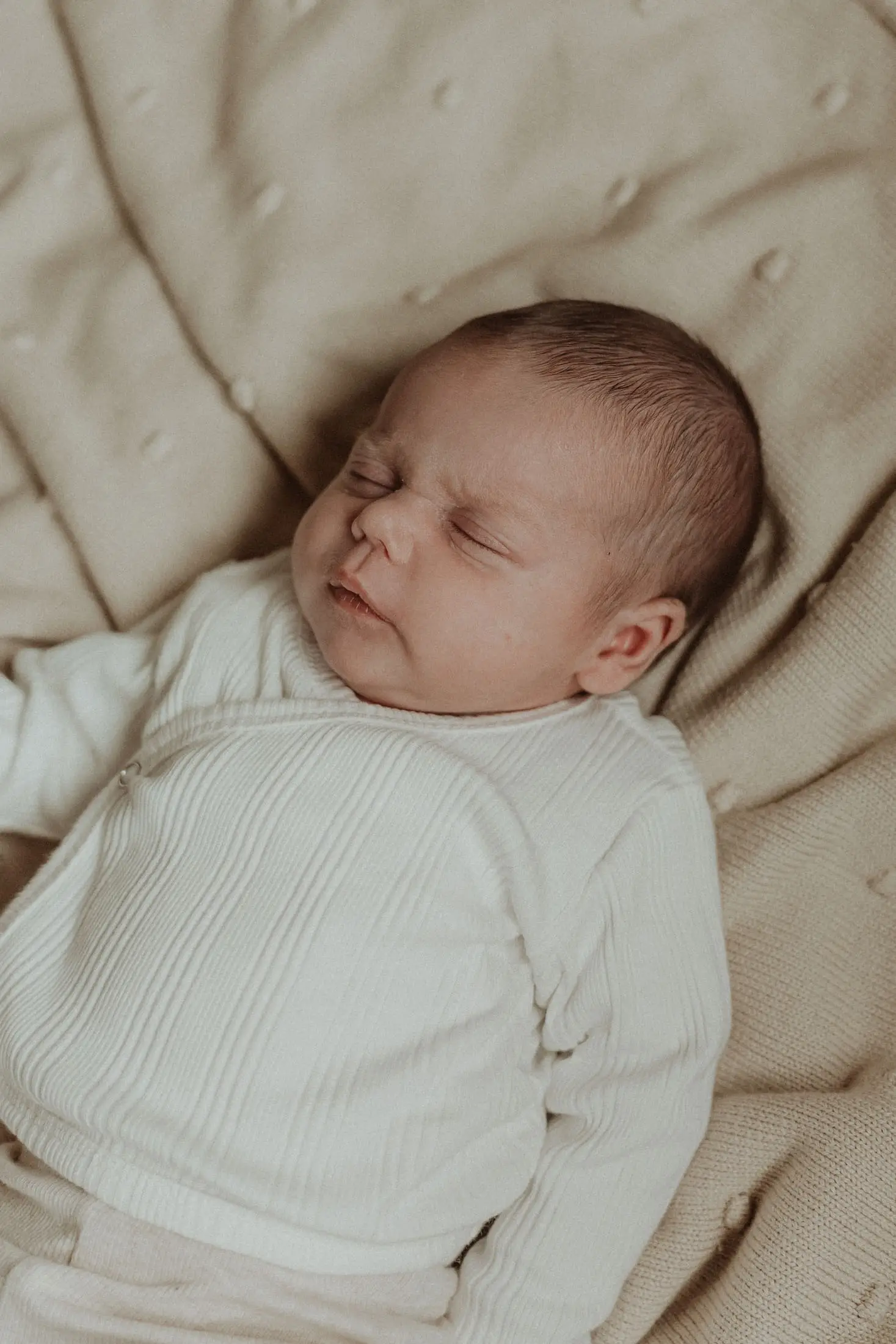 Pasgeboren baby slaapt rustig op een zachte deken